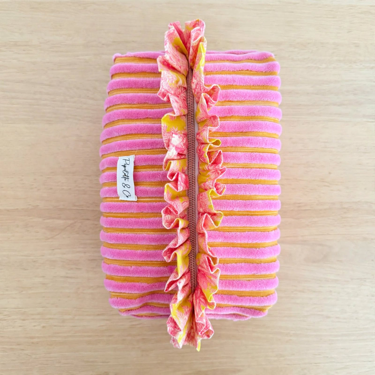 Trousse de toilette velours rose vue de dessus avec volant fleuri Kenzo le long de la fermeture